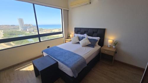 a bedroom with a bed with a view of the ocean at La PERLA DEL MORRO in Porlamar