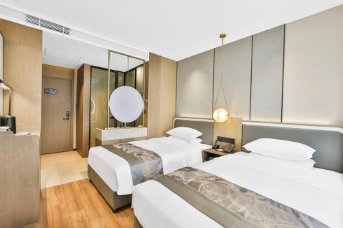 a hotel room with two beds and a bathroom at 黑河易达酒店 in Heihe