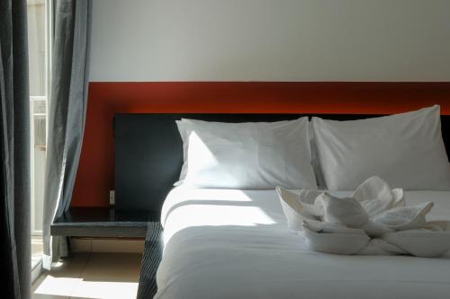 a bed with two white pillows and a red headboard at The 501 by Shmoo in Sliema