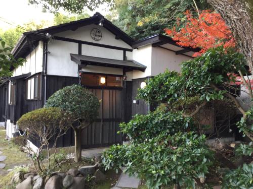 a house with a black and white at Bamboo Village Guest House in Naoshima