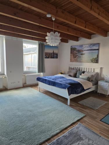 a bedroom with a large bed and a wooden ceiling at Auszeit Tor zur Eifel in Euskirchen