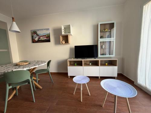 a living room with a table and a tv at Vinaka Etna in Biancavilla