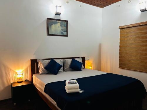 a bedroom with a large bed with blue pillows at Nature Land in Alleppey
