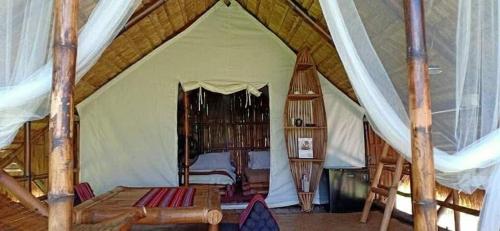 a bedroom with a canopy bed in a tent at Mudita Glamping and Villas Tarlac in Mababanaba