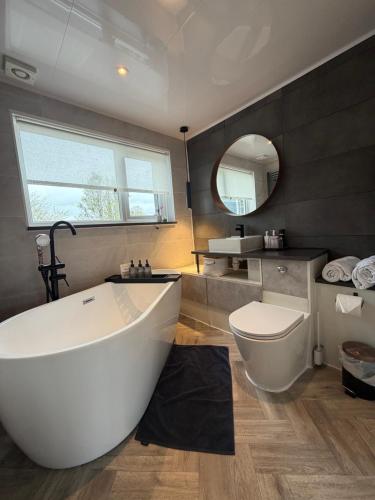 a bathroom with a large white tub and a toilet at Park Terrace Family Room in Glastonbury