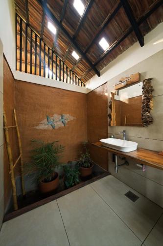 a bathroom with a sink and a mirror and plants at Aalterra Resort by The Almanac in Wayanad