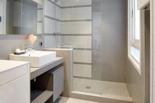 a white bathroom with a sink and a shower at La Terraza by FeelFree Rentals in San Sebastián