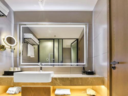 a bathroom with a sink and a large mirror at 黑河易达酒店 in Heihe