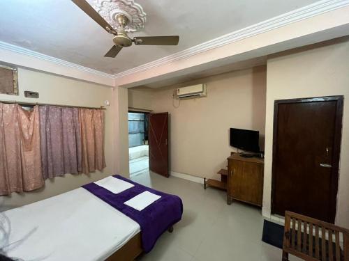 a bedroom with a bed and a ceiling fan at Hotel Golden Palace in Chhatarpur