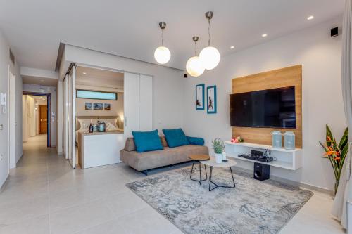 a living room with a couch and a tv at Angels Suites in Plataniás