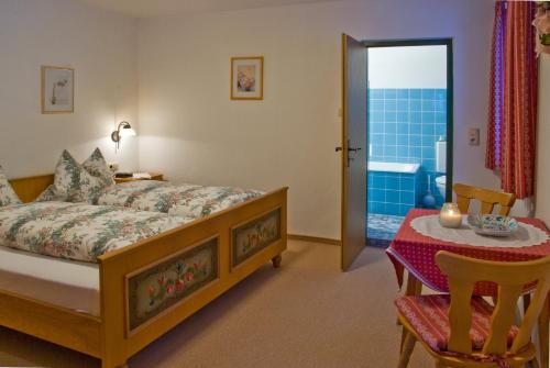 una camera da letto con un letto, un tavolo e un bagno di Leitnerhof a Bad Reichenhall