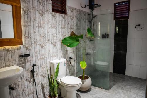 a bathroom with a toilet and a shower and a sink at Zov Wild Yala in Kataragama