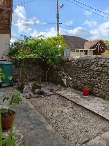 a garden with a stone wall and some plants at Chambre privée Orthez in Orthez