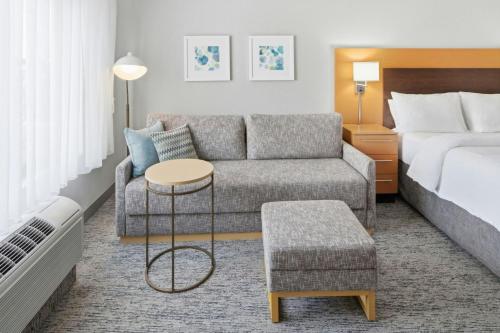 a hotel room with a couch and a bed at TownePlace Suites Farmington in Farmington