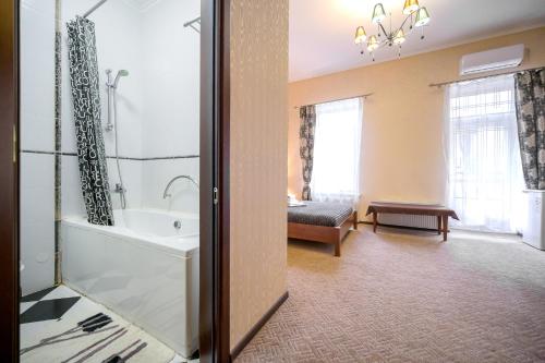 a bathroom with a tub and a sink and a bath tub at Hotel European 8 in Odesa