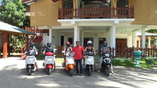a group of people on scooters parked in front of a building at Hotel Birds View in Tissamaharama
