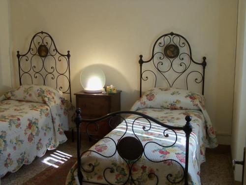 een slaapkamer met 2 bedden en een tafel met een lamp bij Casa O in Pescaglia