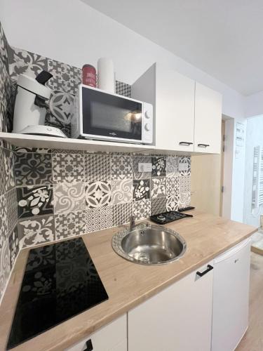 a kitchen with a sink and a microwave at Studio 2 Résidence Eugénie in Eaux-Bonnes