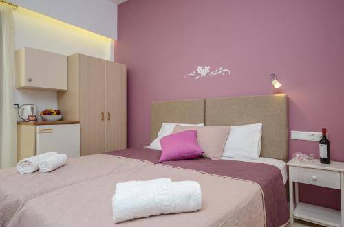 a bedroom with a large bed with purple walls at Panormos Hotel and Studios in Naxos Chora