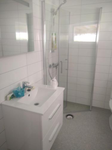 a white bathroom with a sink and a shower at Nernesholmen in Nes