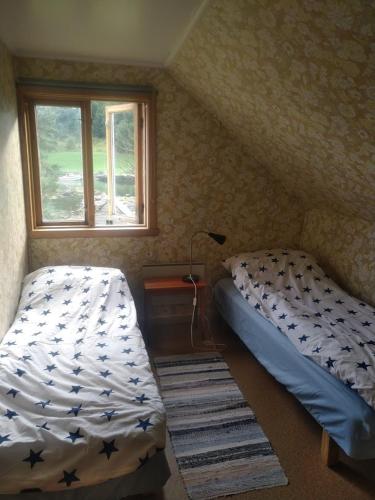a bedroom with two twin beds and a window at Nernesholmen in Nes