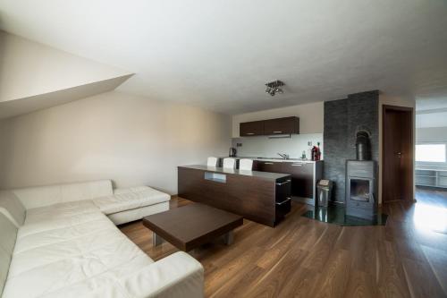 a living room with a couch and a kitchen at Apartmány Janka + camp in Bešeňová