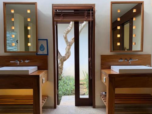 a bathroom with two sinks and a mirror at Villa Bukit Segara in Amed