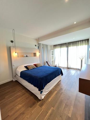 a bedroom with a large bed with a blue blanket at Maison d'Hôtes Bastia in Bastia