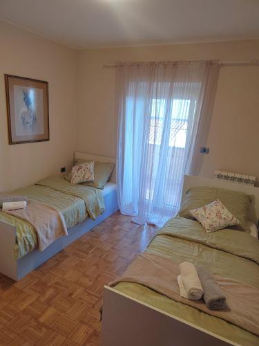 a bedroom with two beds and a window at Villa Bella Vista - For up to 6 people Villa with Sea & Castle view in Črni Kal