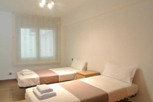 two beds in a small room with a window at Aiguaneu Sa Marina in Blanes