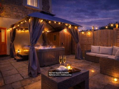 a patio with a hot tub and a tent with lights at Annexe with Courtyard & Hot Tub Option in Wroxall