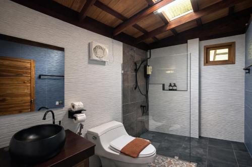 a bathroom with a shower and a toilet and a sink at Nalintara resort นลินธารารีสอร์ท in Ban Pha Saeng Lang