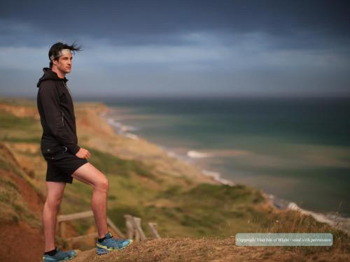 a man standing on top of a hill overlooking the ocean at Annexe with Courtyard & Hot Tub Option in Wroxall