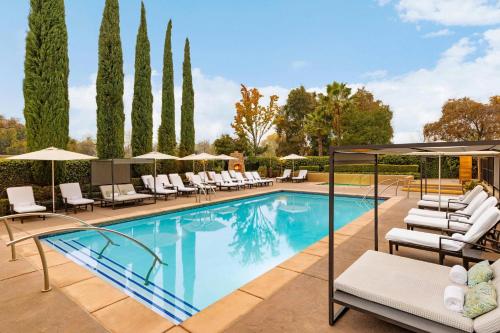 a swimming pool with lounge chairs and umbrellas at The Westin Sacramento Riverfront Hotel & Spa in Sacramento