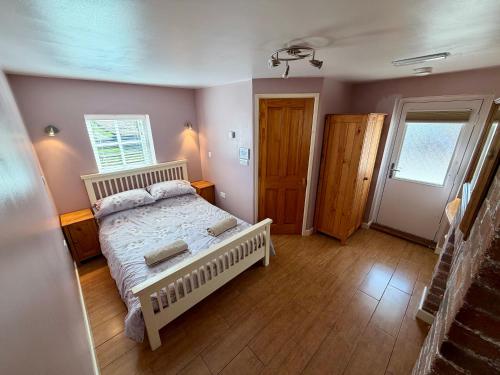 a bedroom with a bed and a wooden floor at The Signal Box at Cliburn Station in Penrith