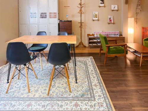 a dining room with a table and chairs on a rug at Suzuki Guesthouse in Kyoto