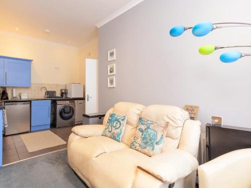 a living room with a chair and a kitchen at Annexe with Courtyard & Hot Tub Option in Wroxall