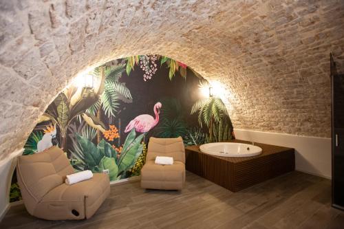 a bathroom with a mural of flamingos and a tub at Suite San Gaetano in Conversano