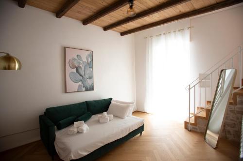 a living room with a green couch and a window at Suite San Gaetano in Conversano