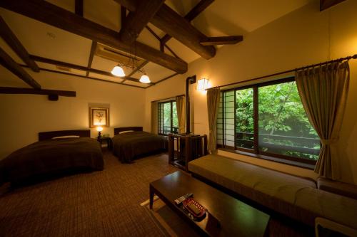 una camera con due letti e una grande finestra di Fujiya a Minamioguni