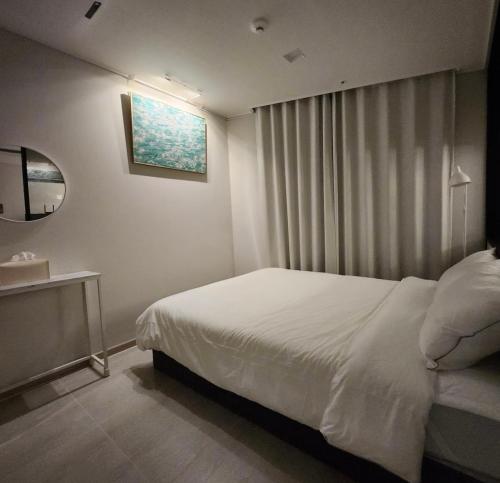 a bedroom with a white bed and a window at 광안비치스테이&Spa in Kwangan-dong