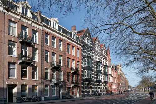 a row of brick buildings on a city street at Marnix360apartments Jordaan in Amsterdam