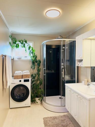 a bathroom with a shower and a washing machine at Large apartment with parking in Sandefjord
