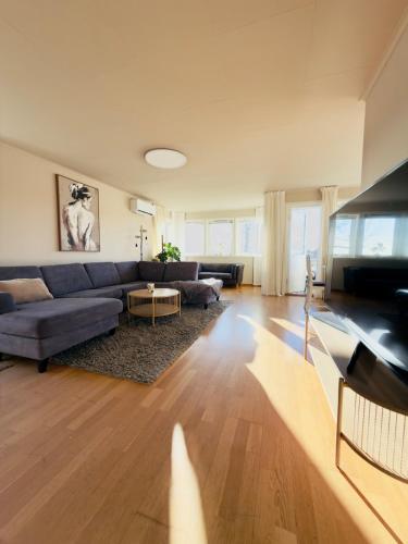 a living room with a couch and a table at Large apartment with parking in Sandefjord