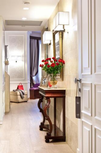 a room with a table with a vase of flowers on it at The Ashbee Hotel in Taormina