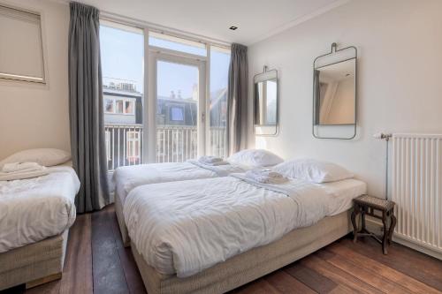a bedroom with two beds and a large window at Marnix360apartments Jordaan in Amsterdam