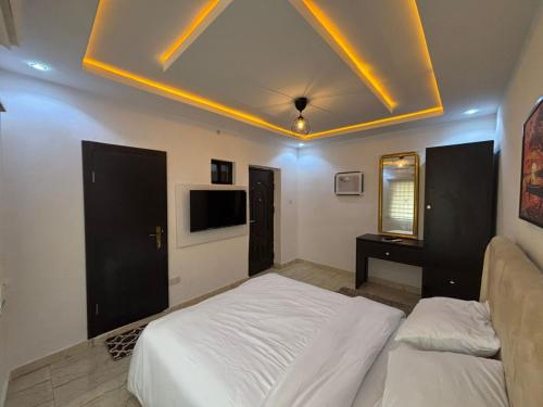 a bedroom with two white beds and a tv at Q2Shortlet Apartment in Isheri-Olofin