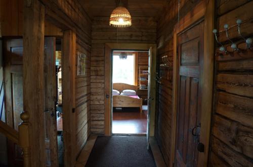 a hallway in a log cabin with a door and a bedroom at Järve Talu Puhkemaja in Otepää
