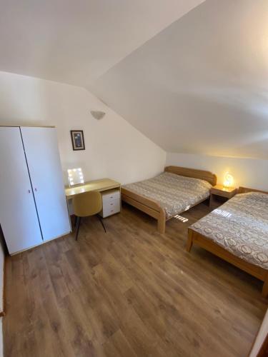 a room with two beds and a desk and a refrigerator at INO Apartments in Tivat