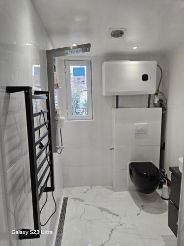 a bathroom with a black toilet and a window at Emmanuel INN XI in Pierrefitte-sur-Seine
